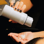 Thickening Conditioner wordt uit de flacon in een handpalm geknepen